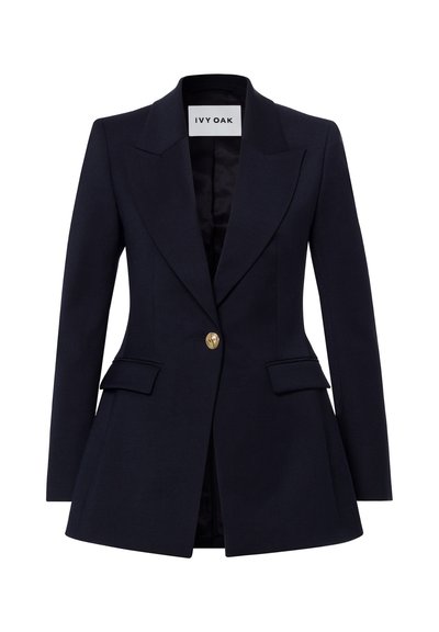 Blazer bleu marine cintré pour femme avec larges revers, fermeture par un bouton doré, poches à rabat et taille structurée de Ivy Oak.