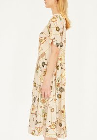 Beżowa sukienka z krótkim rękawem, prezentująca radosny wzór kolorowych motywów, marszczoną spódnicę i luźny krój. Wykonana z lekkiego materiału.