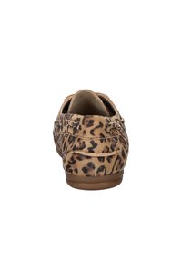 Leopardprint suède instappers met een lage bruine rubberen zool en decoratieve stiksels langs de zijkanten en achterkant.