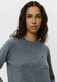 Maglione grigio a maglia con un ricamo "voilà" testurizzato sul davanti. Design con scollatura rotonda e maniche lunghe.