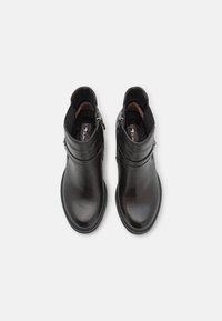 Botas de cuero negro hasta el tobillo con punta redondeada, cremallera lateral y detalles de costura alrededor de la suela. El interior cuenta con un forro suave.