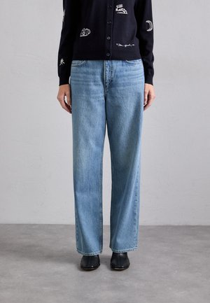 Hellblaue Denim-Jeans mit weitem Bein, hoher Taille, klassischem Fünf-Taschen-Design und sanften Auswaschungen. Präsentiert mit einer dunkelblauen Strickjacke.
