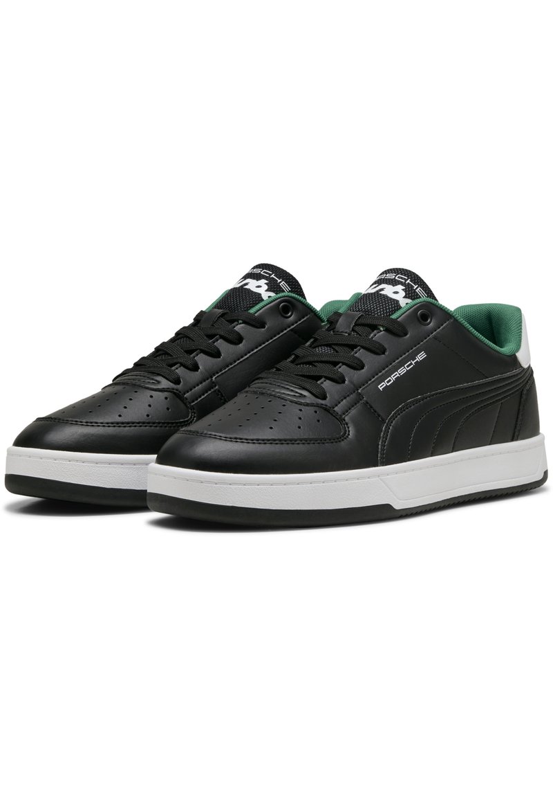 Black leather sneakers with green accents, white rubber sole, perforated toe, and black laces. Features logo on tongue and side.