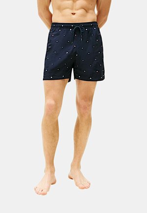 Costumi da bagno blu navy con cintura regolabile, caratterizzati da un motivo di piccoli punti multicolori e un tessuto leggero e liscio.