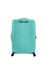 Kova hard-shell matka laukku teal-värissä, jossa on teksturoitu pinta, yläkahva, sivukahva ja neljä mustaa pyörää liikkuvuutta varten.