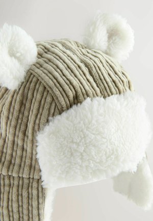 Chapeau en gabardine avec doublure en peluche blanche. Présente des oreilles d'ours et des rayures en velours côtelé beige texturé. Les rabats d'oreilles doublés s'étendent vers le bas.
