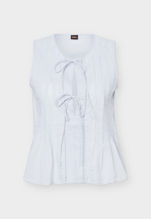 Blouse blanche sans manches avec encolure ronde, dotée de deux fermetures à nouer à l'avant et de plis verticaux sur le devant et les côtés.