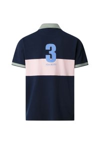 Polo azul marino con una franja horizontal rosa claro, cuello y puños verde claro, número 3 grande en azul y texto "Hackett" en la parte trasera.