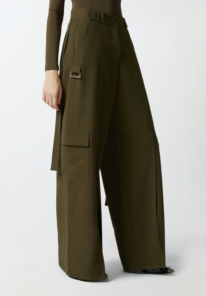 Hlače širokih nogavica od maslinasto zelene tkanine, s bočnim terenskim džepovima, elegantnim zatvaračem i akcentima od srebrne boje. Glatka tekstura.