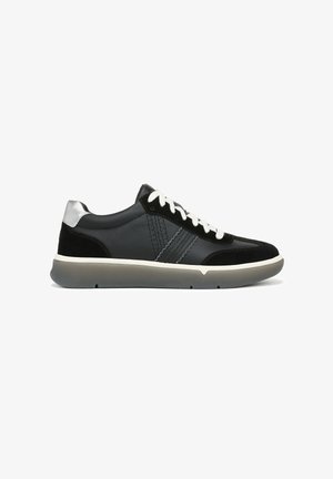 Black leather and suede sneaker with white laces, silver heel detail, stitched side stripes, and thick gray sole, shown from side view.