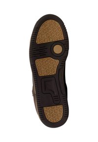 Semelle de chaussure avec une surface texturée noire et des grips en motif de nid d'abeille marron. Des accents circulaires améliorent la traction.