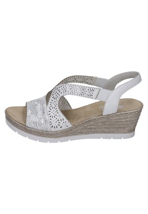 Sandale compensée blanche avec un design floral perforé, des brides texturées et une plateforme beige. Caractéristiques : arrière fermé et semelle intérieure rembourrée.