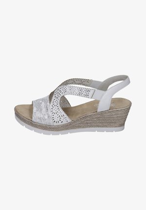 Sandale compensée blanche avec un design floral perforé, des brides texturées et une plateforme beige. Caractéristiques : arrière fermé et semelle intérieure rembourrée.