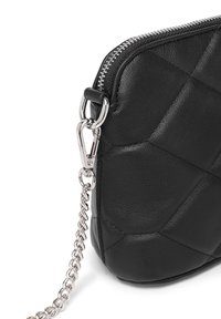 Schwarze gesteppte Lederhandtasche mit einem silbernen Metallreißverschluss. Verfügt über ein abnehmbares Kettenriemen und eine strukturierte Oberfläche mit geometrischen Musterakzenten.