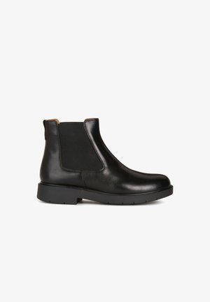 Bottines Chelsea en cuir noir avec des panneaux latéraux élastiques, un bout arrondi et une semelle en caoutchouc texturé avec un léger talon.