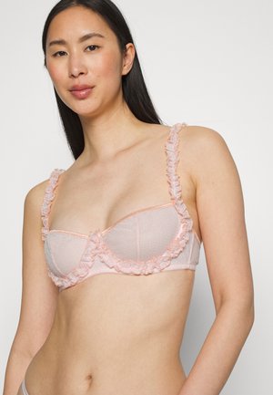 Sutiã em rosa claro com borda de renda rendada ao longo das extremidades e alças, apresentando um padrão texturizado e suporte de aros.