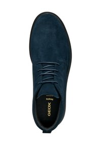 Chaussures pour hommes en daim bleu marine avec un design à lacets, semelle en caoutchouc, et logo doré sur la semelle intérieure. Présentent un bout arrondi et une texture lisse.