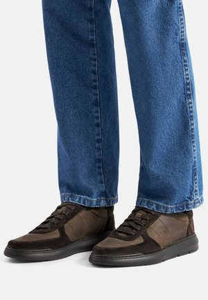 Brązowe wysokie sneakersy z skóry i zamszu z czarną gumową podeszwą, posiadające sznurowane zapięcie i kontrastujące panele.