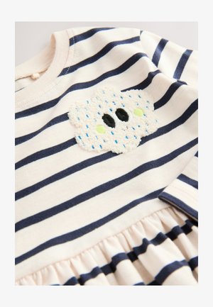 Rochie roz deschis cu dungi orizontale bleumarin. Are o aplicație pufoasă în formă de nor cu ochi negri și accente verzi, talie strânsă și guler striat.