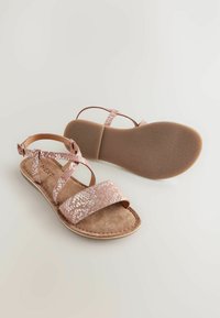 Rosa platta sandaler med texturerade ormtryckremmar, justerbar ankle buckle och en mjuk brun mockasula på en flexibel tan sula.