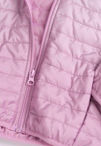 Veste matelassée rose clair avec une fermeture éclair à l'avant, présentant une texture satinée lisse et des lignes de couture visibles.