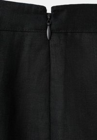 Tissu noir avec une fermeture éclair noire centrée sur la couture du haut, montrant un matériau tissé texturé et une languette de fermeture éclair fermée.