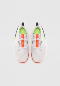 Hvite og grå atletiske sko med mesh-overdel, neongrønne detaljer, oransje snøringer og en teksturert såle; har en pull-tab og logo.