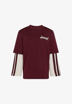 Donkerrood t-shirt met korte mouwen, gedragen over witte lange mouwen met donkerrode strepen, met klein wit Adidas-logo op de linker bovenborst.
