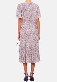 Bloemen midi-jurk van lichtgewicht stof met korte vlindermouwen, patronen in blauw, rood en wit, gesmockte taille en gelaagde zoom.