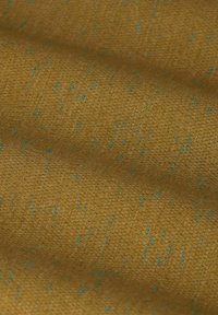 Strukturierter Stoff in goldbraun mit blauen Sprenkeln. Das Gewebe zeigt ein subtile Muster, das eine einladende visuelle Tiefe und Weichheit erzeugt.