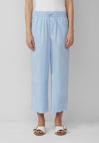 Pantalons courts, amples et bleu clair avec une taille �élastique et un cordon de serrage. Texture lisse, ourlets fini et poches latérales.