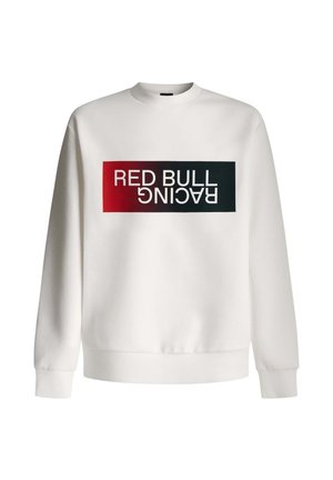 Balta sporta krekla tranšejā ar taisnstūra grafiku, kurā redzams teksts "RED BULL RACING" treknrakstā melnā un sarkanā krāsā. Klasisks apkakles dizains.
