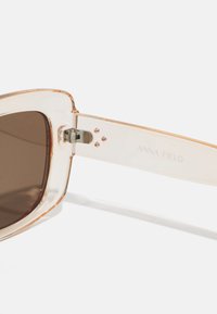 Brauntönte Sonnenbrille mit einem klaren, leicht getönten Acetatgestell. Verfügt über ein silbernes Scharnier und den eingravierten Markennamen Anna Field am Arm.