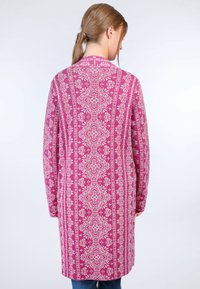 Long pink cardigan with white floral and geometric patterns, featuring a classic collar and long sleeves, made from a soft knitted material.