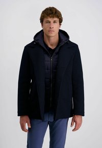 Marineblauer Mantel mit Rippstruktur, knöpfbarem Vorderteil, breiten Revers und einer Kapuze im Innenbereich. Mit einem Reißverschluss und seitlichen Taschen ausgestattet.