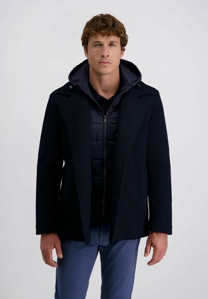 Marineblauer Mantel mit Rippstruktur, knöpfbarem Vorderteil, breiten Revers und einer Kapuze im Innenbereich. Mit einem Reißverschluss und seitlichen Taschen ausgestattet.