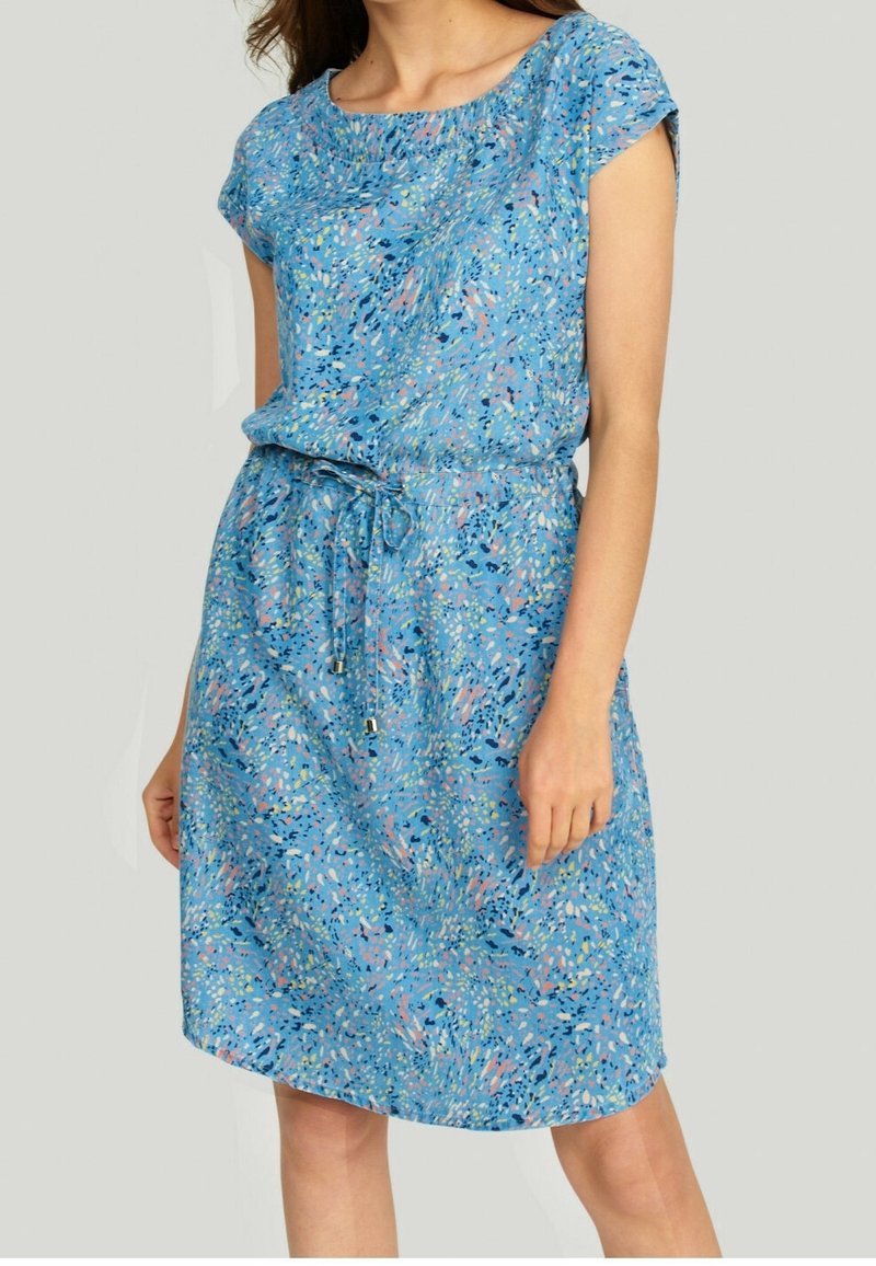 Robe bleue à manches courtes avec une taille cintrée, présentant un motif abstrait coloré en rose et vert. Tissu léger et coupe décontractée.