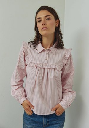 Blusa a strisce rosa con giogo, colletto e maniche lunghe arricciati. Presenta chiusura con bottoni e tessuto raccolto per una vestibilità comoda.