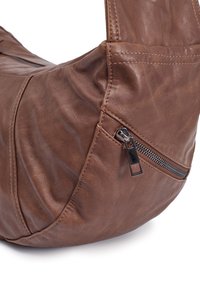 Braune Ledertasche mit glatter Textur, geschwungenem Design und einem Reißverschlusstaschen-Detail an der Seite. Schlichte Nähte betonen das Design.