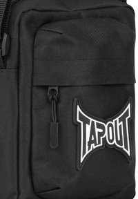 Schwarzer Stoffrucksack mit einem auffälligen TAPOUT-Logo in Weiß, mehreren Reißverschlusstaschen und strukturierter Oberfläche für Langlebigkeit.