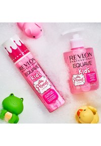Butelki odżywki i szamponu Revlon Equave Kids w różowym kolorze, z zabawnymi wzorami koron, umieszczone w pienistej wodzie z zabawkami do kąpieli.