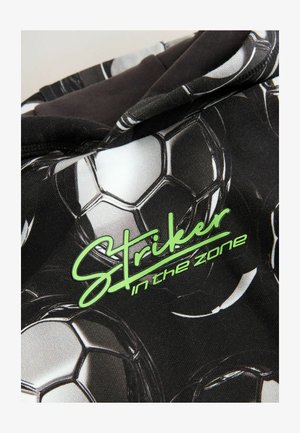 Sudadera negra con un patrón de balones de fútbol. El texto en verde dice "Delantero en la zona". Tejido suave con una textura lisa.