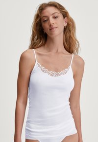 Witte tanktop met dunne banden, voorzien van een bloemenkantafwerking langs de halslijn. Gemaakt van lichtgewicht, soepel materiaal.