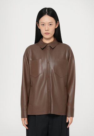 Giacca camicia in finta pelle marrone con colletto, chiusura a bottoni e due tasche sul petto. Texture liscia e vestibilità sartoriale.
