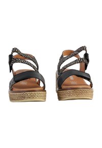 Sandales à talons noirs avec un design de bride tissée et une plateforme texturée. Dotées d'une semelle de style espadrille. Légères et ouvertes à l'avant.