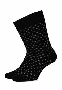 Czarne skarpetki z wzorami przedstawiającymi małe białe kształty. Materiał wydaje się miękki, z wzmocnionym ściągaczem u góry.