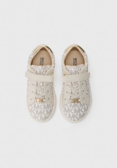 Μπεζ αθλητικά παπούτσια με υφή στο επάνω μέρος που παρουσιάζουν επαναλαμβανόμενο μοτίβο λογότυπου. Περιλαμβάνουν ιμάντα με βέλκρο και διακοσμητικές χρυσές λεπτομέρειες.