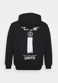 Felpa nera con cappuccio che presenta una grande grafica bianca sul retro con il testo "CREW" e un design a pennellate verticali. Maniche lunghe e cappuccio.