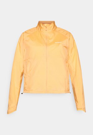 Könnyű, sárga széldzseki magas gallérral, teljes hosszúságú cipzárral és logó részlettel. Rugalmas mandzsettákkal és állítható alsó résszel rendelkezik.