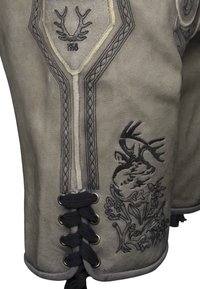 Prenda tradicional de ante gris con intrincados bordados negros que presentan astas y un diseño floral. Muestra cordones decorativos y detalles trenzados.